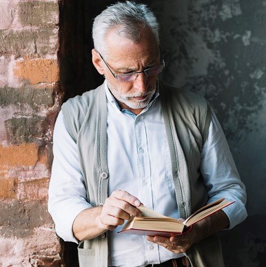 Mature man reading a book with an expression of consentration