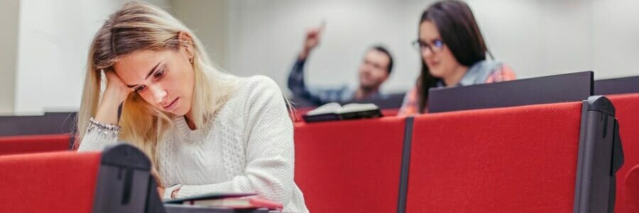 Young woman stating at her textbook with a frustrated expression