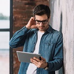 Young man starting at his tablet in hand