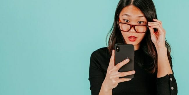 Woman staring at her smartphone with a perplexed expression