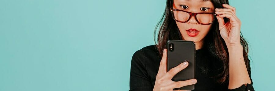 Woman staring at her smartphone with a perplexed expression