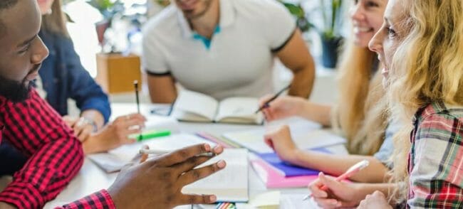 group of colleagues working together with paper and books in front of them