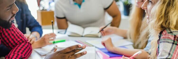 group of colleagues working together with paper and books in front of them