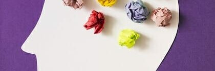 Construction paper made to look like human head with crumpled paper made to look like human brain