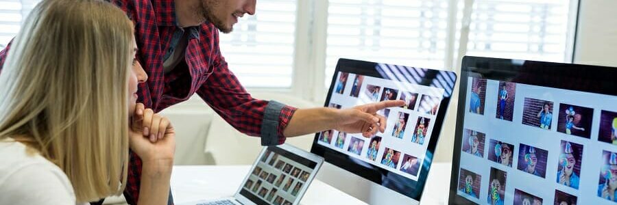 Male and female graphic designers interacting over computer