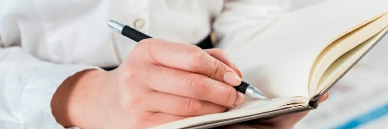 Close up of student taking notes in a notebook