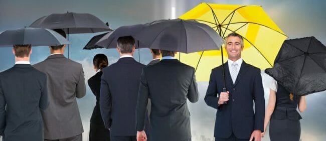 OGA5J60a Older male with a yellow umbrella standing out in a crowd