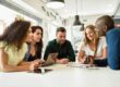 Multi-ethnic group of young people studying together on white de