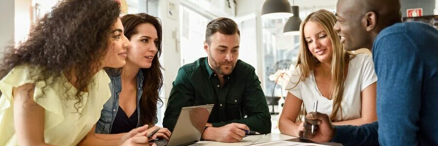 Multi-ethnic group of young people studying together on white de