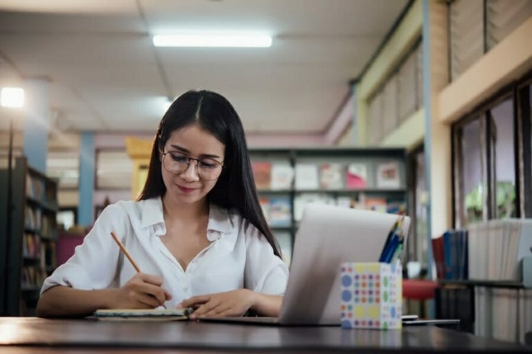 Young students learning,library bookshelves on background