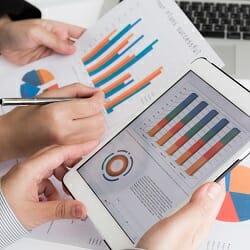 Close-up of business team using digital tablet with financial d