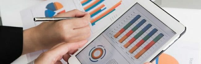 Close-up of business team using digital tablet with financial d