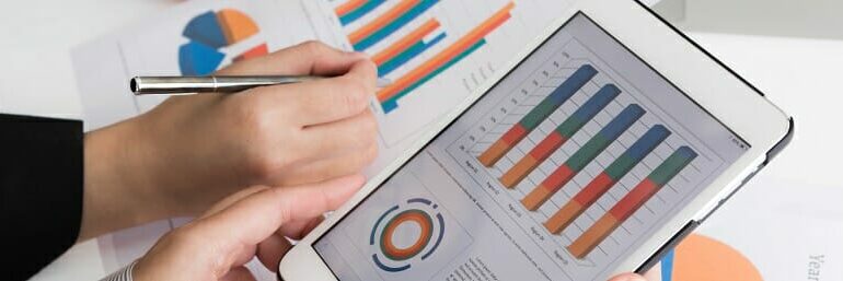Close-up of business team using digital tablet with financial d