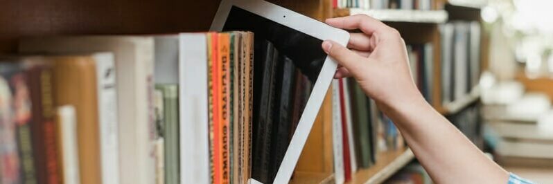 Student taking iPad off bookshelf