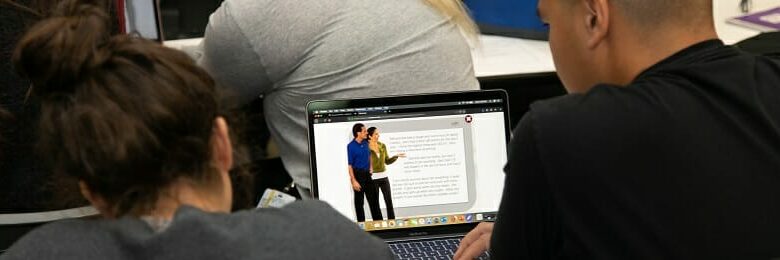 Students looking at case study on laptop