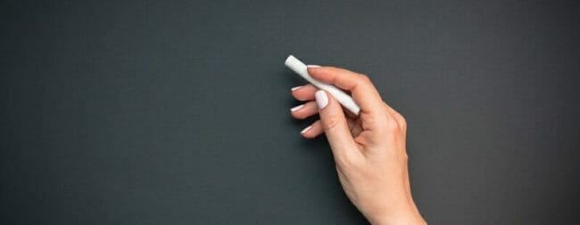 Teacher hand with piece of chalk