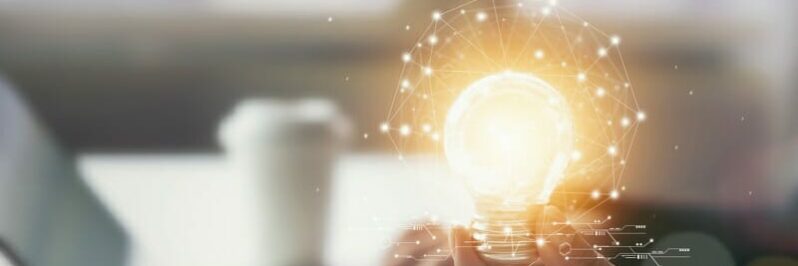 Hand holding light bulb with innovative and creativity are keys to success. Concept knowledge leads to ideas and inspiration.