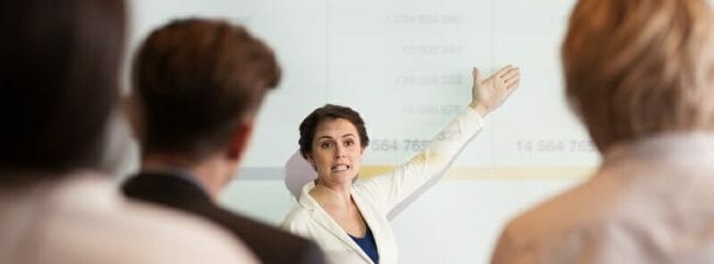Serious Businesswoman Showing Table to Audience