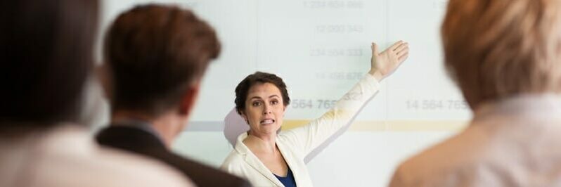 Serious Businesswoman Showing Table to Audience