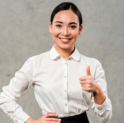 Young woman in business attire performing thumb up gesture