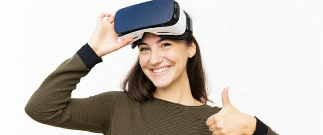 Smiling happy student taking off VR headset Smiling happy student taking off VR headset