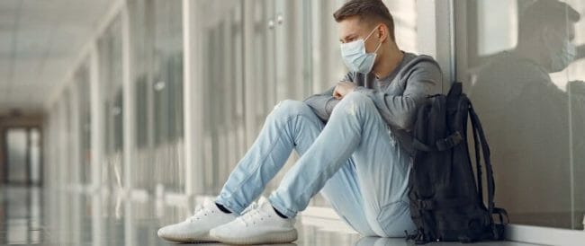 Man in a mask sitting in the hall of hospital Man in a mask sitting in the hall of hospital