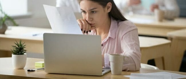 Serious employee attentively reading document focused on thinkin Serious employee attentively reading document focused on thinkin