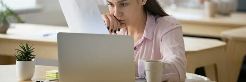 Serious employee attentively reading document focused on thinkin